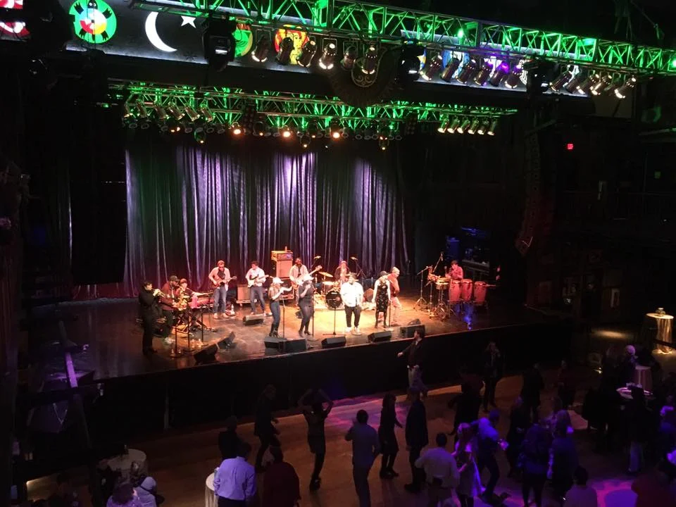 A band playing on a stage for a small crowd